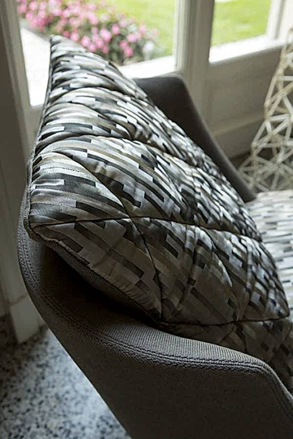 The comfortable cushioning and curved armrests of this modern armchair make it the perfect spot for relaxation and comfort